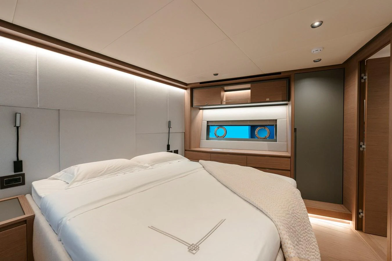 The stateroom features a comfortable bed with modern lighting and elegant wood finishes. aboard LUCKY LUKA Yacht for Sale