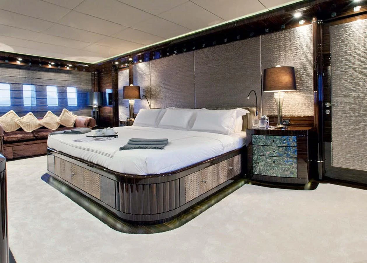 The master stateroom features a luxurious bed with elegant lighting and sophisticated decor. aboard RUSH Yacht for Sale
