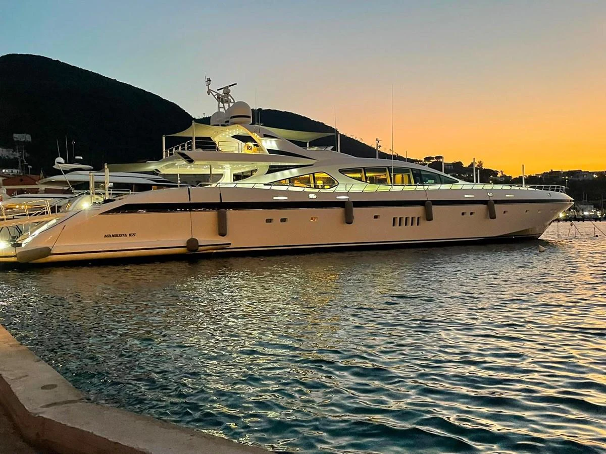 A sleek and luxurious yacht is docked at sunset, showcasing its elegant design and spacious decks. aboard RUSH Yacht for Sale