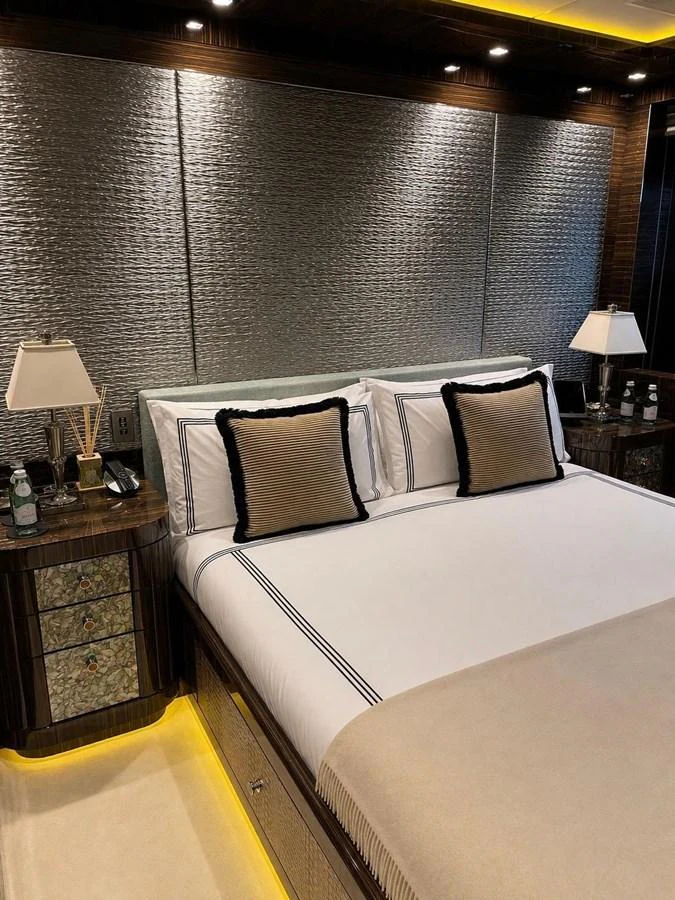 The luxurious stateroom features a plush bed with elegant bedding and ambient lighting. aboard RUSH Yacht for Sale
