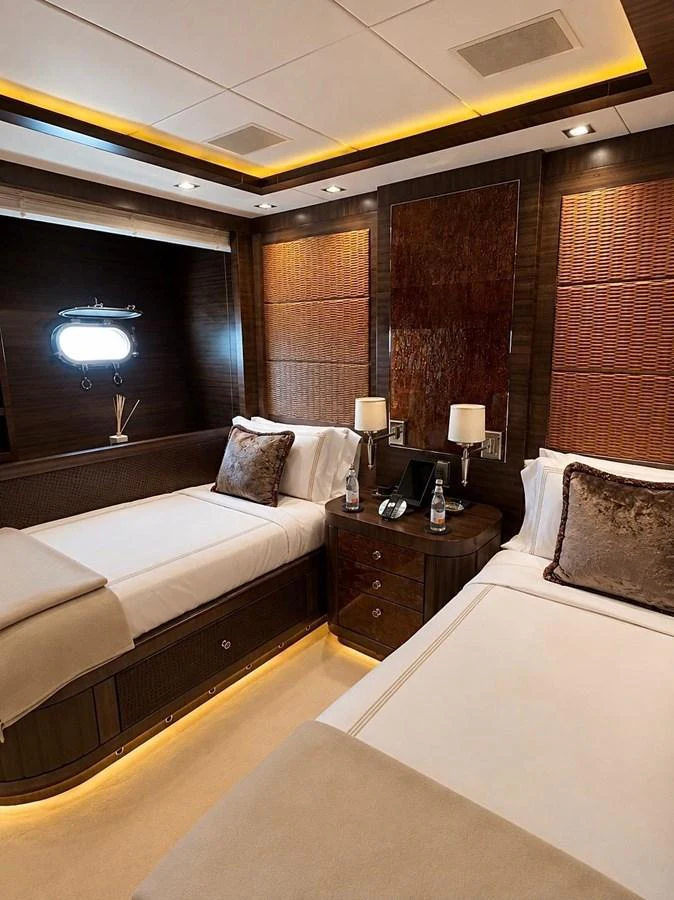 The guest stateroom features twin beds with luxurious bedding and elegant wood finishes. aboard RUSH Yacht for Sale