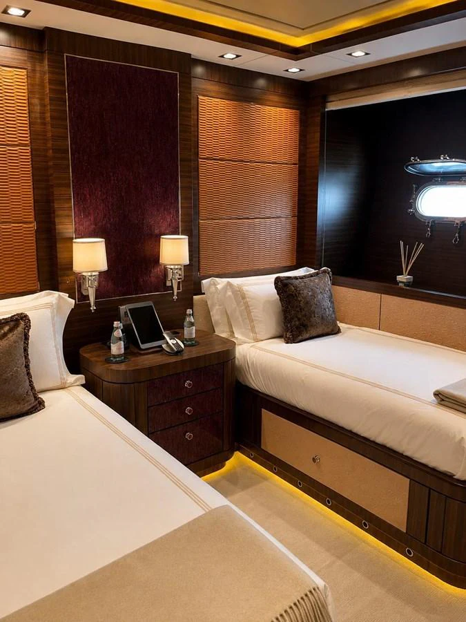 The guest stateroom features twin beds with elegant bedding and warm lighting. aboard RUSH Yacht for Sale