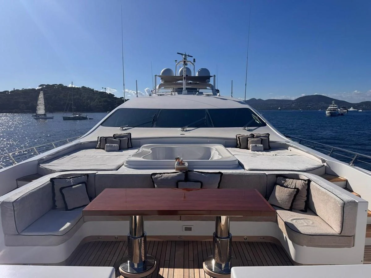 The sundeck offers a luxurious lounging area with ample seating and a central table, perfect for relaxation and socializing. aboard RUSH Yacht for Sale