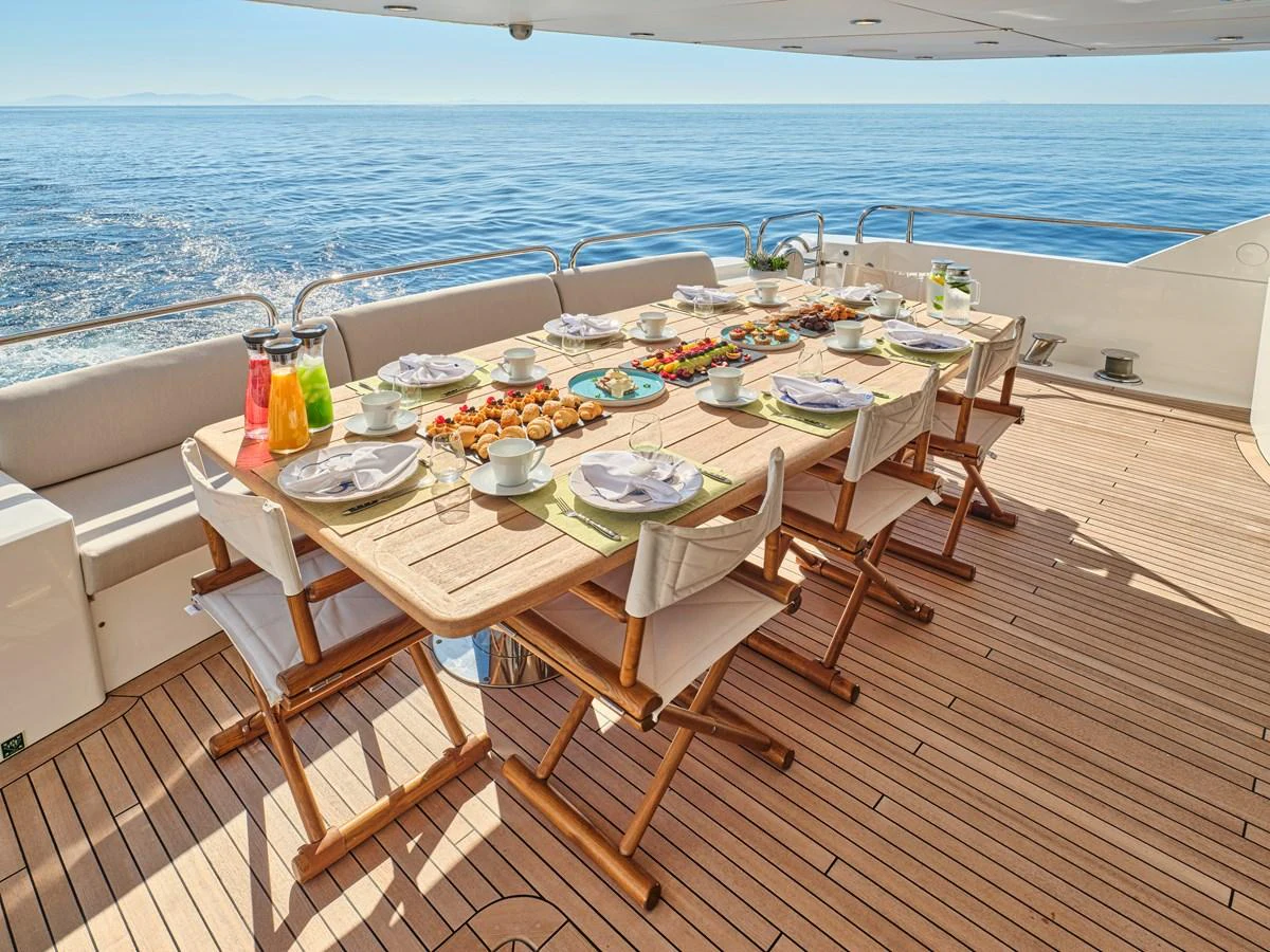 An inviting dining area on the aft deck, set for a meal with a stunning ocean view. aboard BLADE I Yacht for Sale