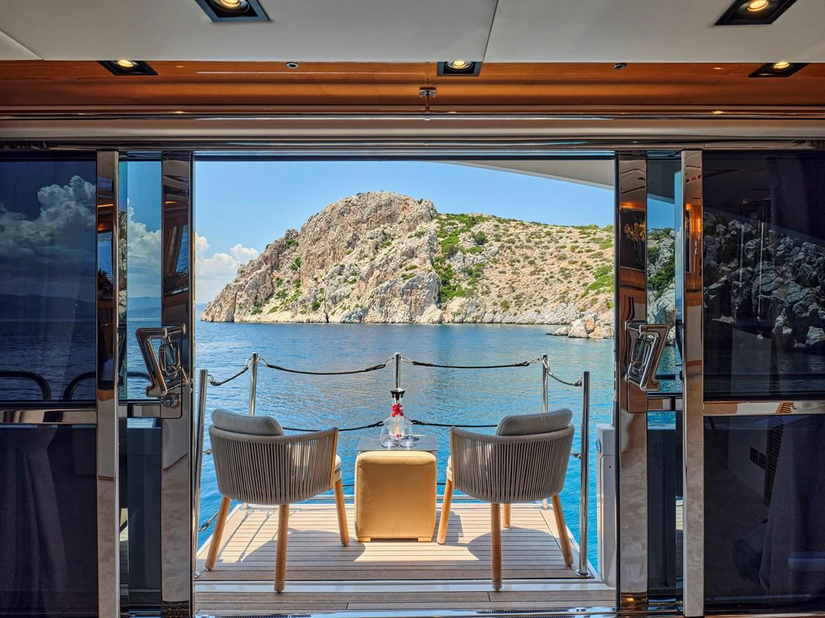 The aft deck offers a serene seating area with a stunning view of the surrounding waters and rocky landscape. aboard BLADE I Yacht for Sale