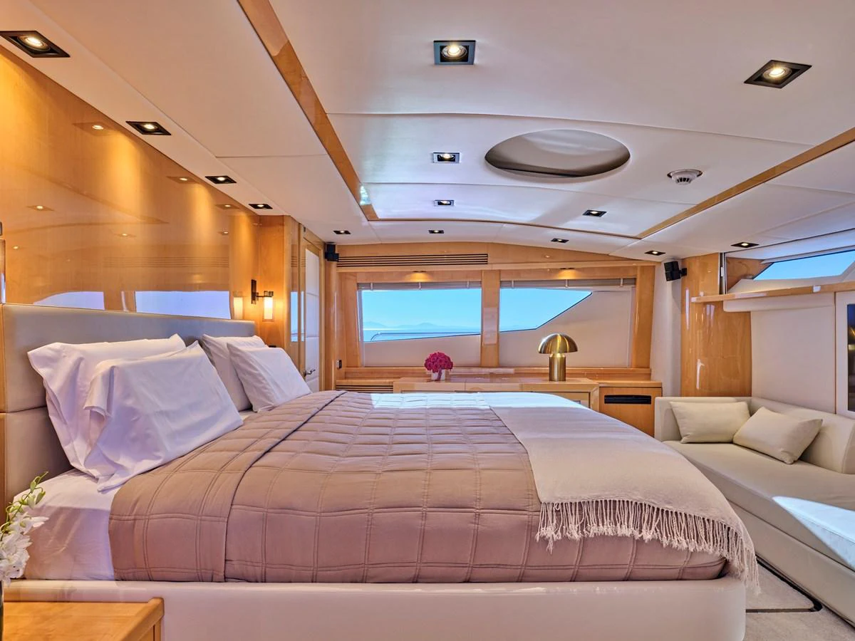The master stateroom features a luxurious bed, elegant lighting, and ample natural light through large windows. aboard BLADE I Yacht for Sale