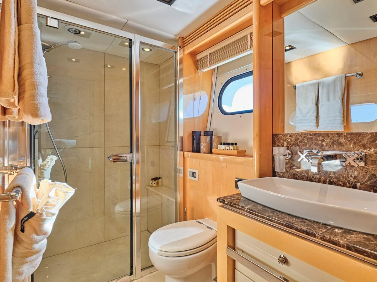 This luxurious yacht bathroom features a spacious shower, elegant fixtures, and ample natural light. aboard BLADE I Yacht for Sale