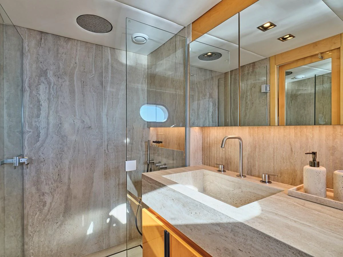The yacht's bathroom features a sleek design with modern fixtures and ample natural light. aboard BLADE I Yacht for Sale