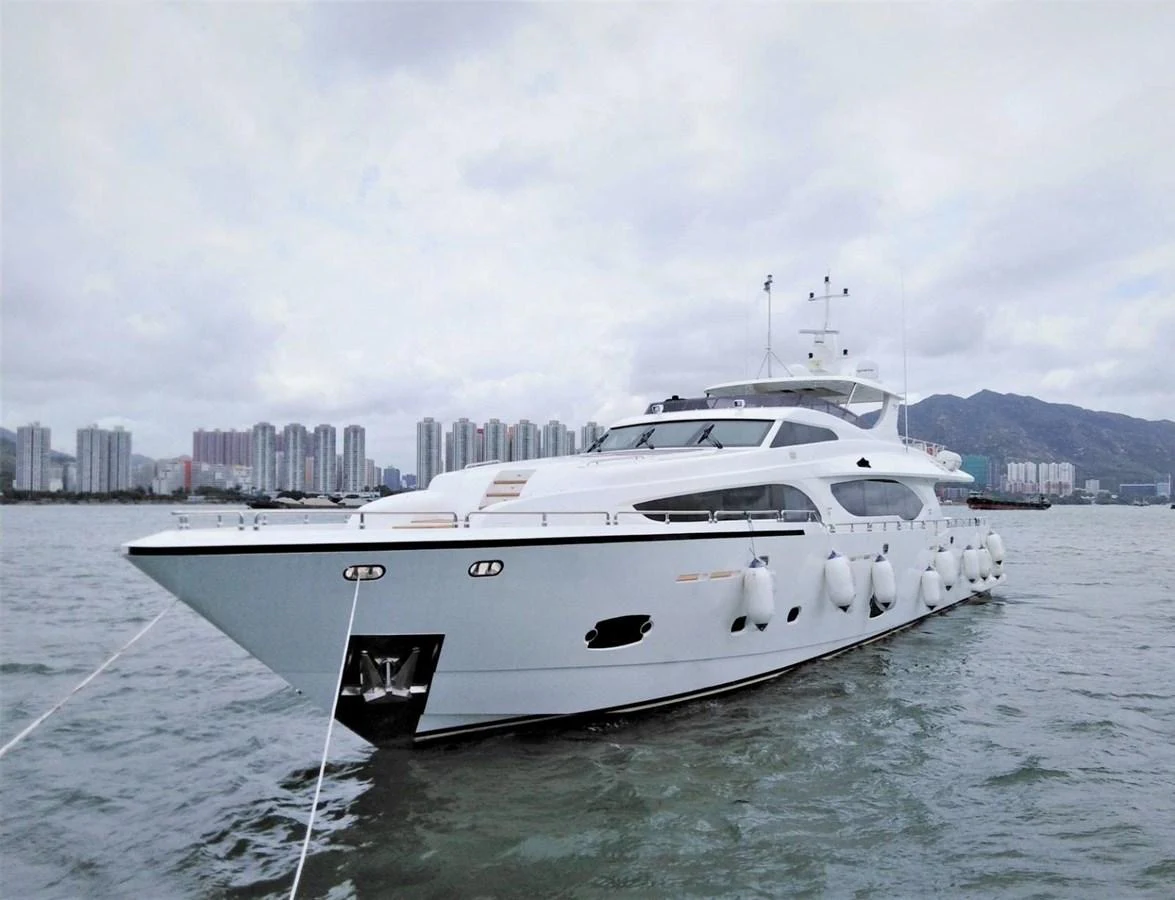 A sleek and modern yacht is anchored in a serene harbor with a cityscape in the background. aboard HEYSEA ASTERIA 126/1 Yacht for Sale