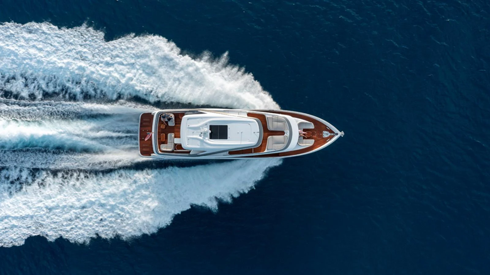Aerial view of a sleek yacht cruising through the open sea, leaving a trail of white wake behind. aboard PRINCESS X80 Yacht for Sale