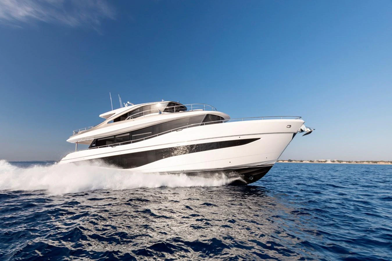 A sleek and modern yacht cruises swiftly on the open sea under a clear blue sky. aboard PRINCESS X80 Yacht for Sale