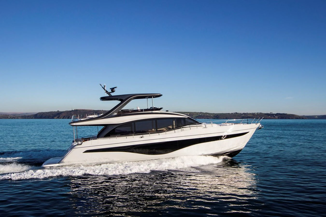 A sleek and modern yacht cruises gracefully on calm blue waters under a clear sky. aboard PRINCESS Y72 Yacht for Sale