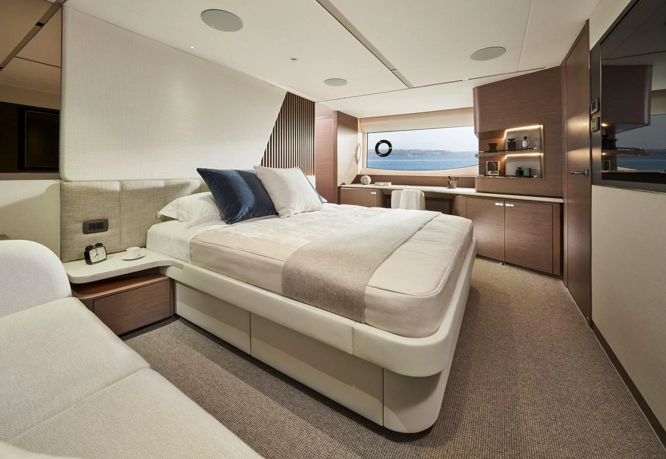 The master stateroom features a luxurious bed, ample storage, and a serene view through the window. aboard PRINCESS Y72 Yacht for Sale