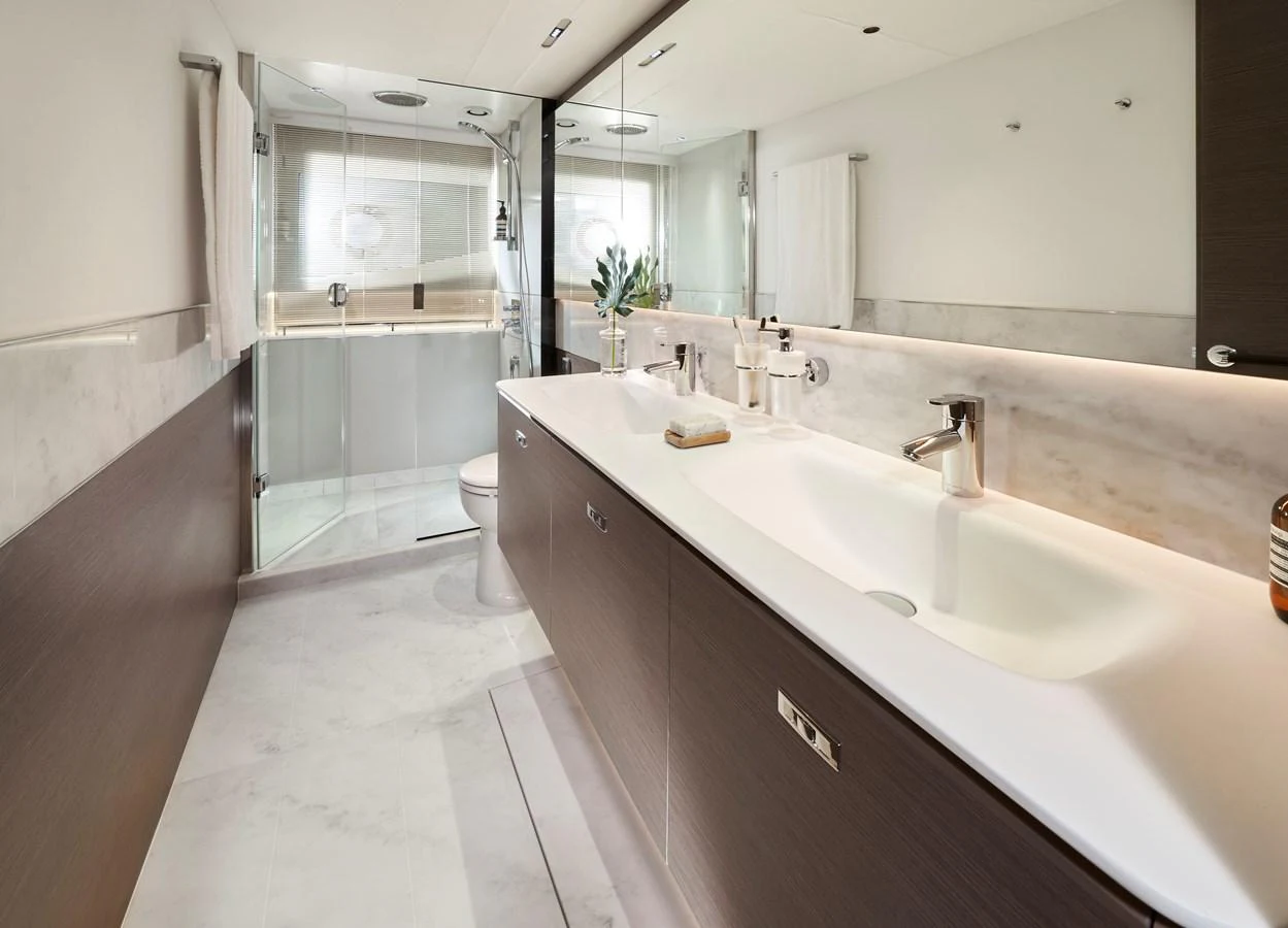 The yacht's bathroom features a spacious and modern design with dual sinks and a large shower area. aboard PRINCESS Y72 Yacht for Sale