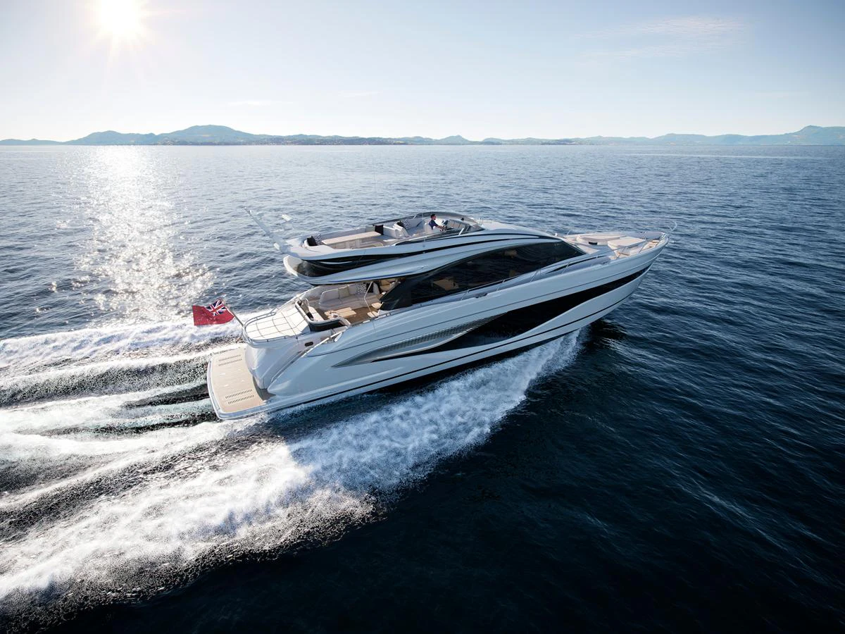 A sleek and modern yacht cruises swiftly through open waters under a clear sky. aboard PRINCESS S74 Yacht for Sale
