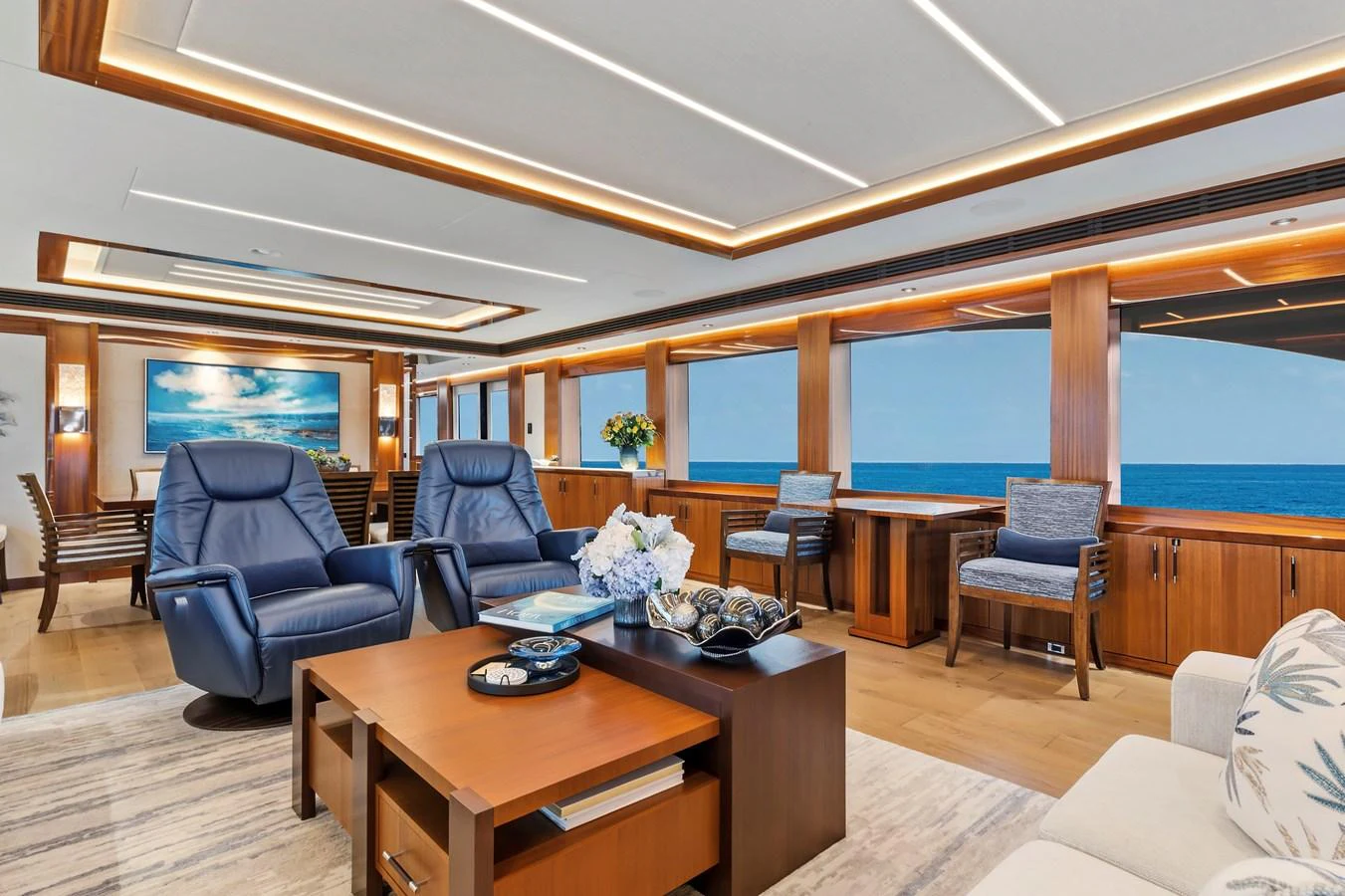 The salon features luxurious seating with panoramic ocean views and elegant wooden accents. aboard SEAS THE DAY Yacht for Sale