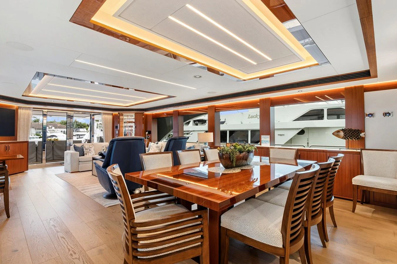 The yacht's dining area features a luxurious wooden table with comfortable seating and elegant lighting. aboard SEAS THE DAY Yacht for Sale