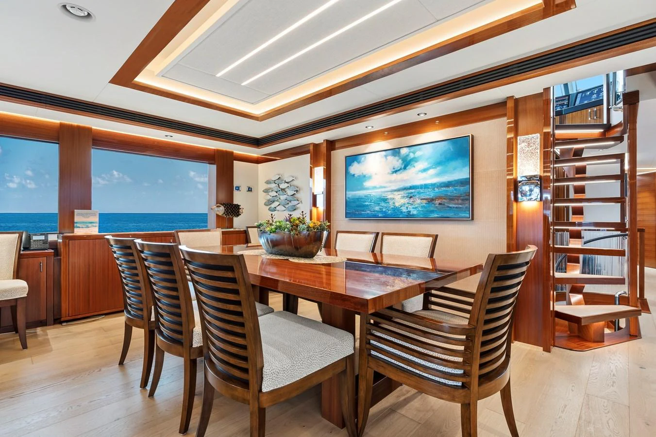 The yacht's dining area features elegant wooden furnishings and a stunning ocean view. aboard SEAS THE DAY Yacht for Sale