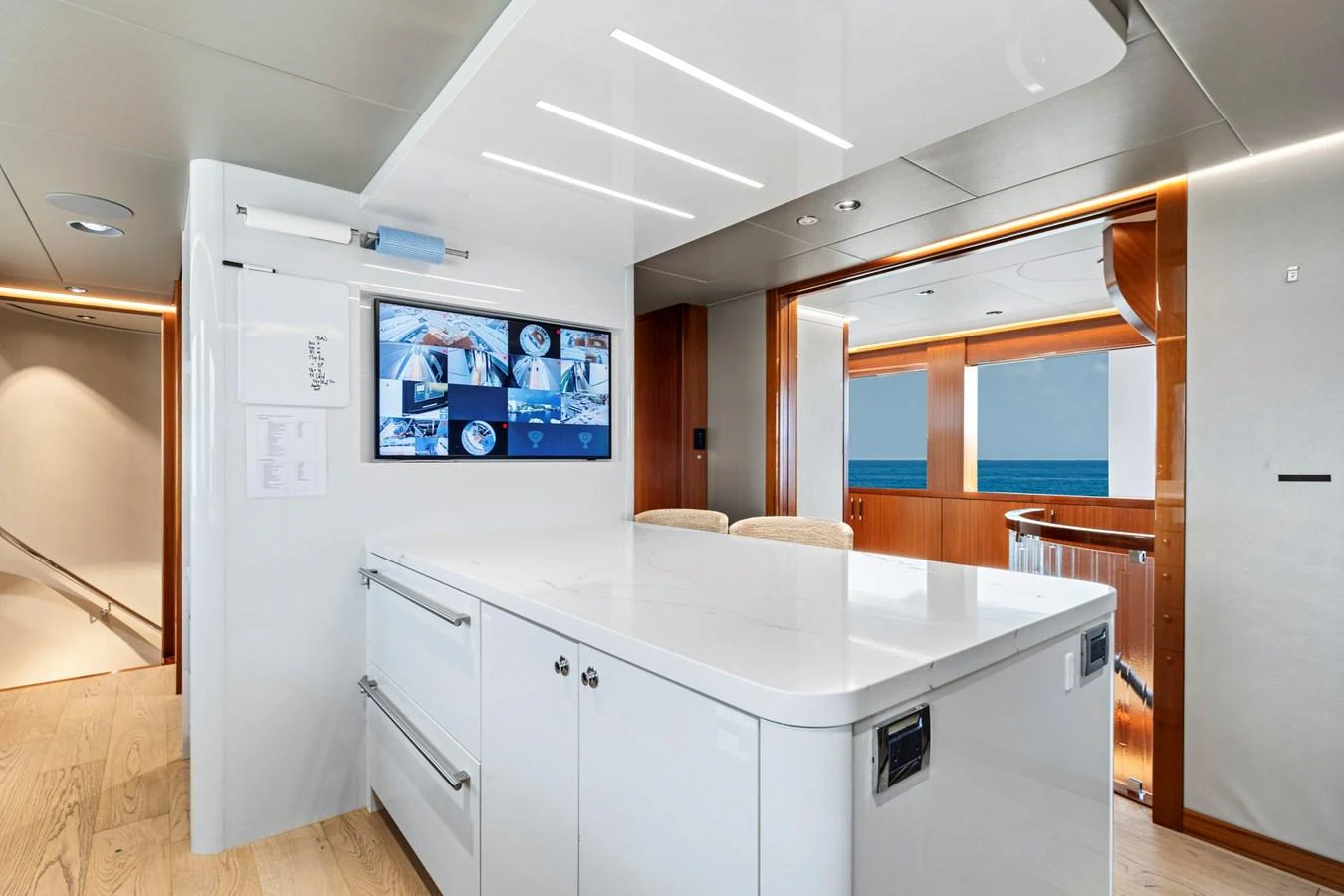 The modern galley features sleek white cabinetry and state-of-the-art appliances, with a view of the ocean through large windows. aboard SEAS THE DAY Yacht for Sale