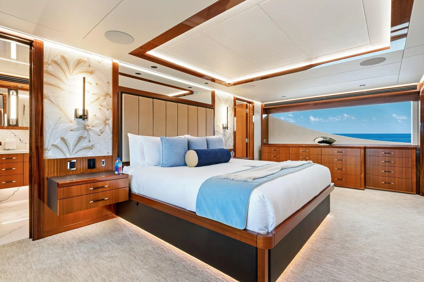 The master stateroom features luxurious bedding, elegant wood finishes, and a stunning ocean view. aboard SEAS THE DAY Yacht for Sale