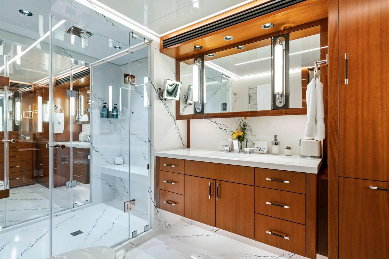 The yacht's bathroom features elegant wood cabinetry and a spacious glass-enclosed shower. aboard SEAS THE DAY Yacht for Sale