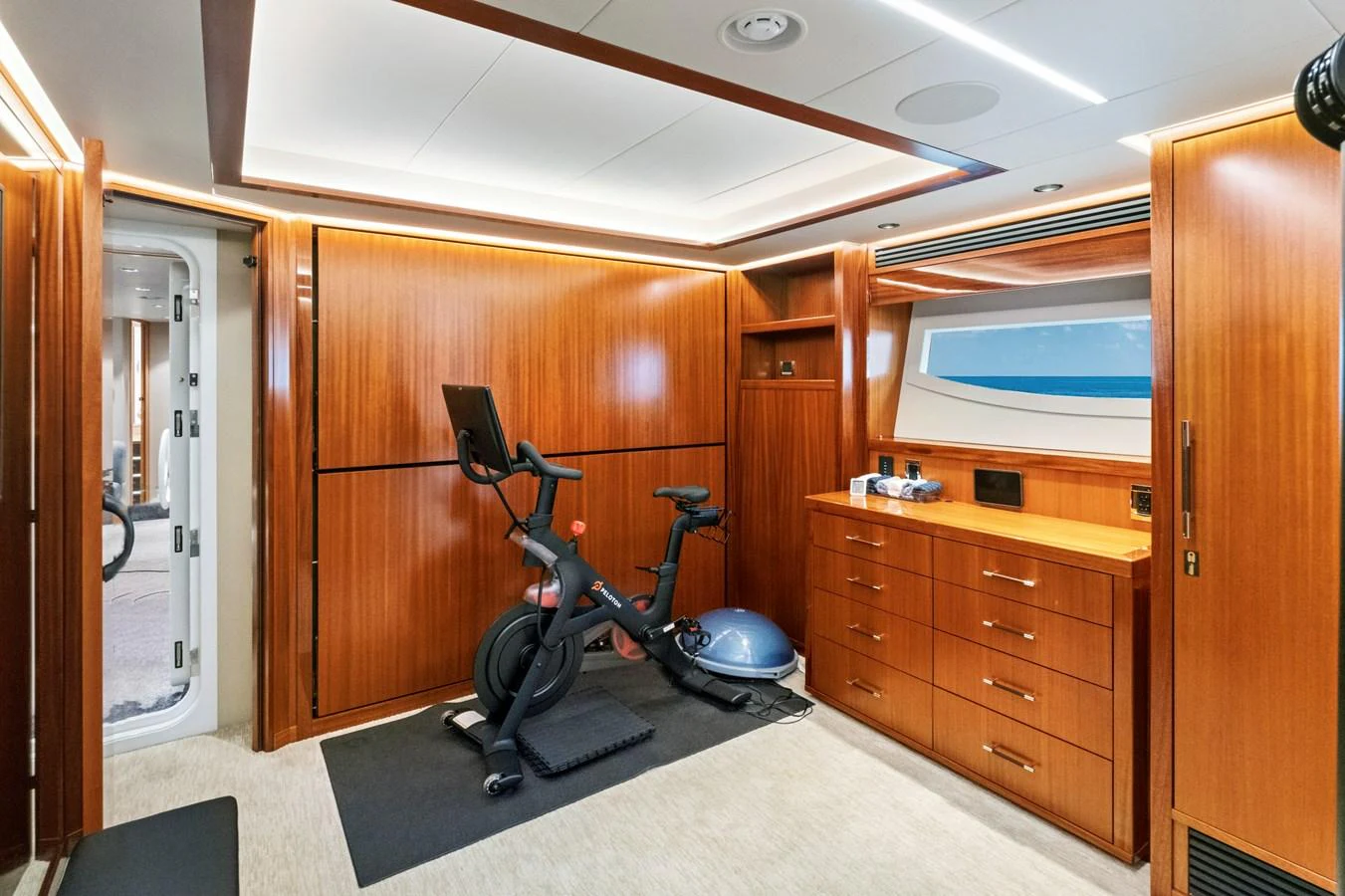 The yacht features a well-equipped gym with modern fitness equipment and ample natural light. aboard SEAS THE DAY Yacht for Sale