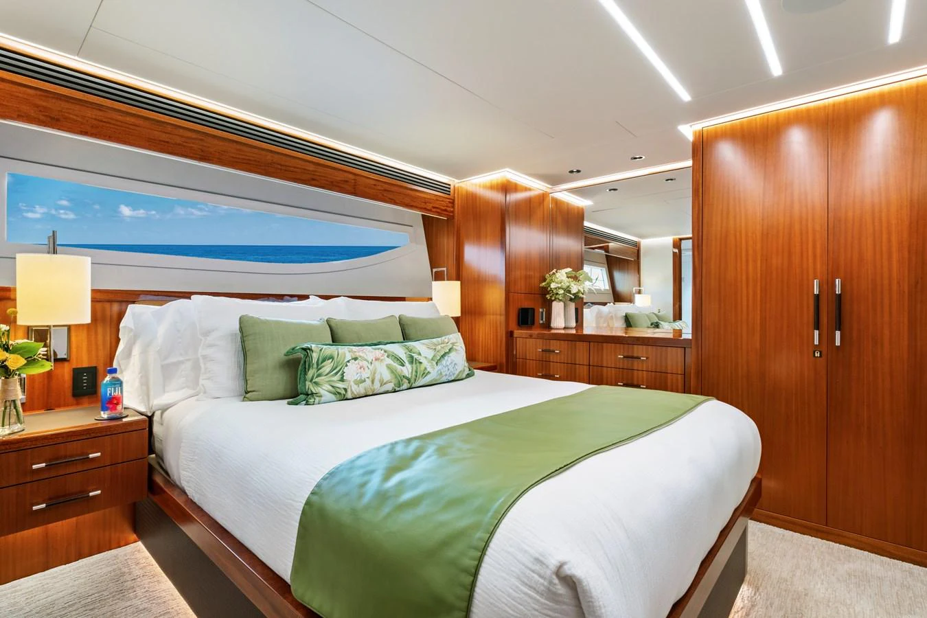 The stateroom features a luxurious bed with elegant wood finishes and modern lighting. aboard SEAS THE DAY Yacht for Sale
