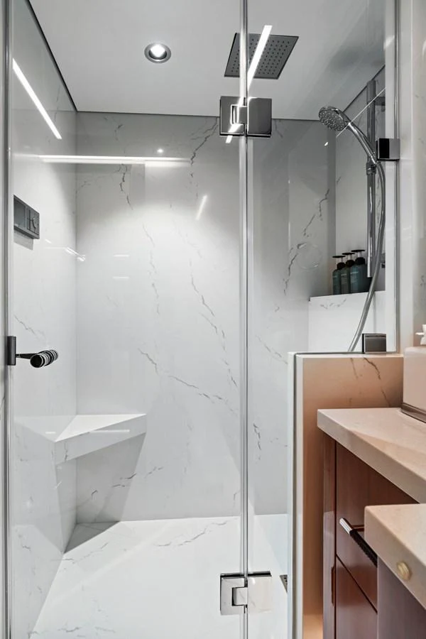The yacht's bathroom features a sleek, modern design with a glass-enclosed shower and elegant fixtures. aboard SEAS THE DAY Yacht for Sale