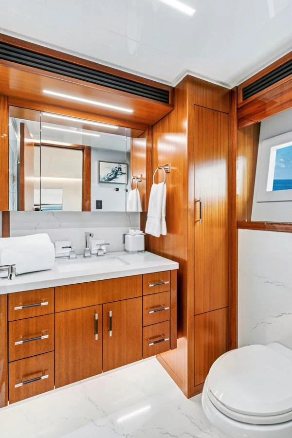 The yacht's bathroom features elegant wood cabinetry and modern fixtures. aboard SEAS THE DAY Yacht for Sale