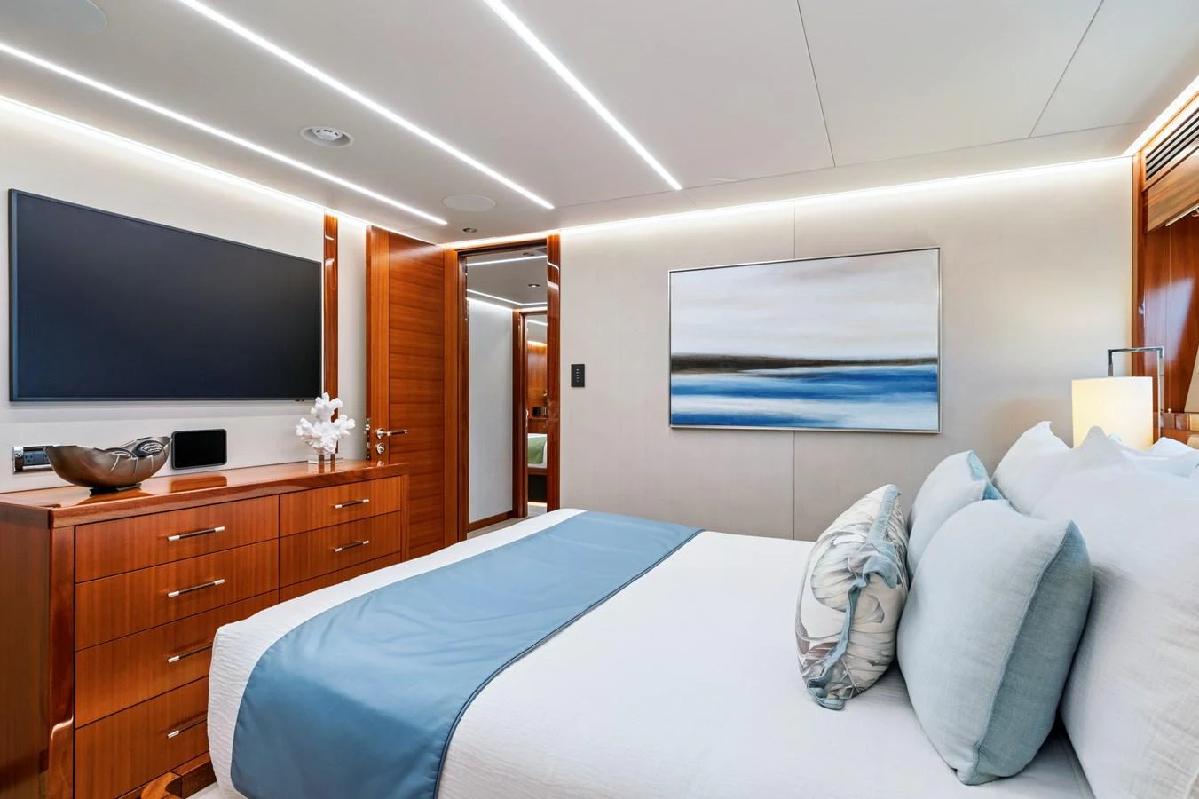 The stateroom features a modern design with a large bed, wooden cabinetry, and a flat-screen TV. aboard SEAS THE DAY Yacht for Sale