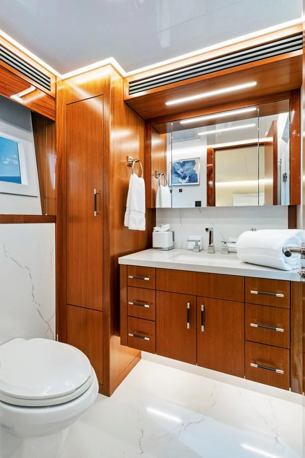 The yacht's bathroom features elegant wood cabinetry and modern fixtures, creating a luxurious and functional space. aboard SEAS THE DAY Yacht for Sale