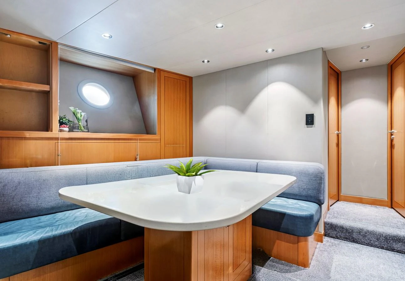 The yacht's dining area features a sleek table surrounded by comfortable seating and warm wood accents. aboard SEAS THE DAY Yacht for Sale
