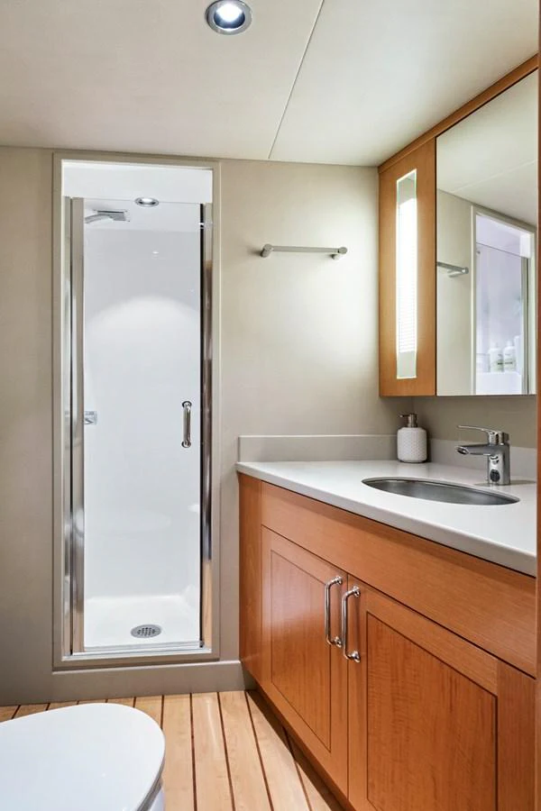 This is a modern bathroom with a sleek shower and wooden cabinetry. aboard SEAS THE DAY Yacht for Sale