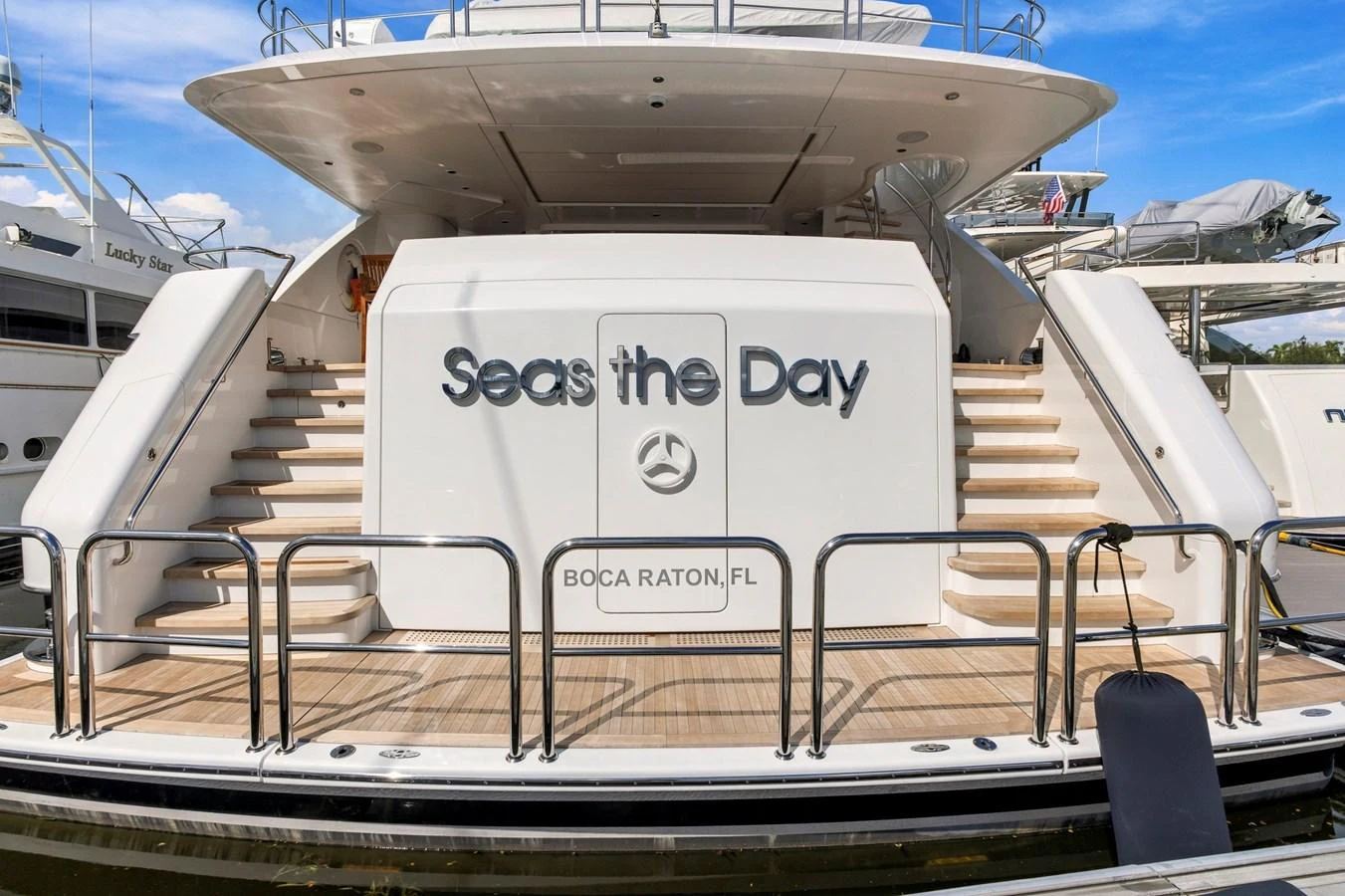 The yacht's aft deck features elegant stairs and a welcoming nameplate. aboard SEAS THE DAY Yacht for Sale