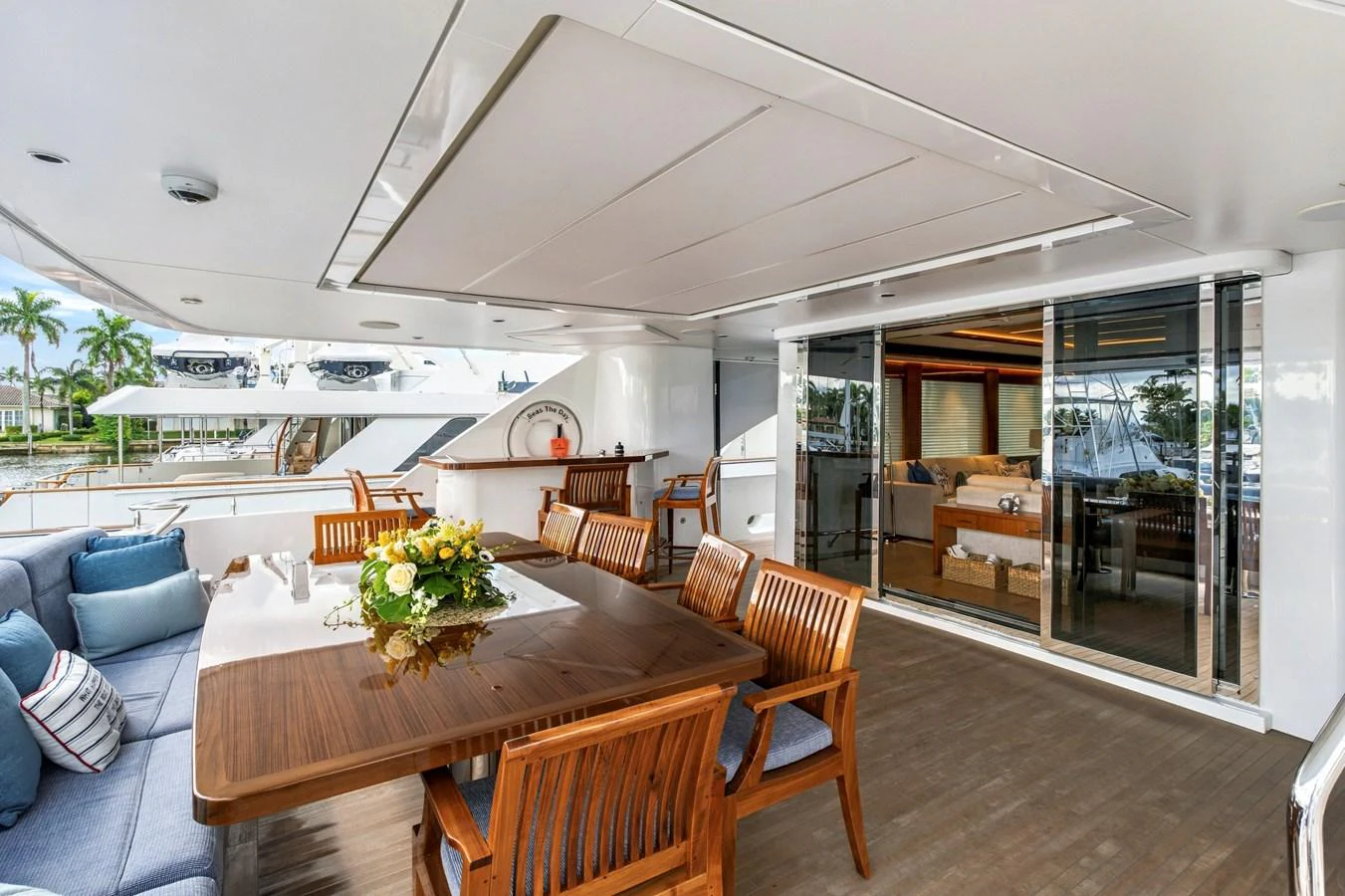 The aft deck features a spacious dining area with elegant wooden furniture and a comfortable seating arrangement. aboard SEAS THE DAY Yacht for Sale