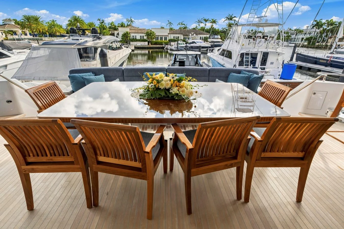 The aft deck features a stylish dining area with a polished table and comfortable wooden chairs, perfect for alfresco dining. aboard SEAS THE DAY Yacht for Sale