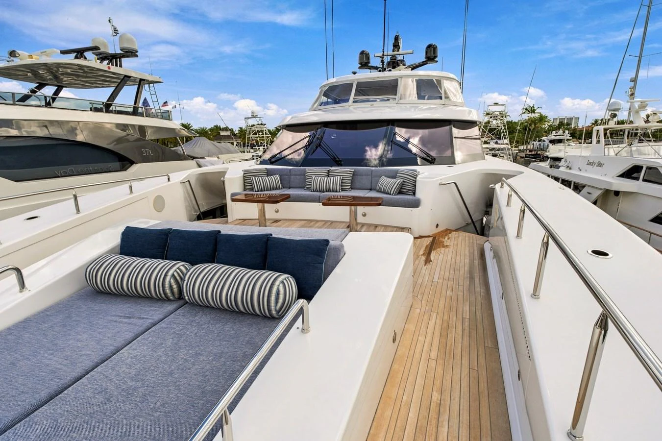 The yacht's foredeck features a spacious sunbathing area with plush cushions and a seating area with a table. aboard SEAS THE DAY Yacht for Sale