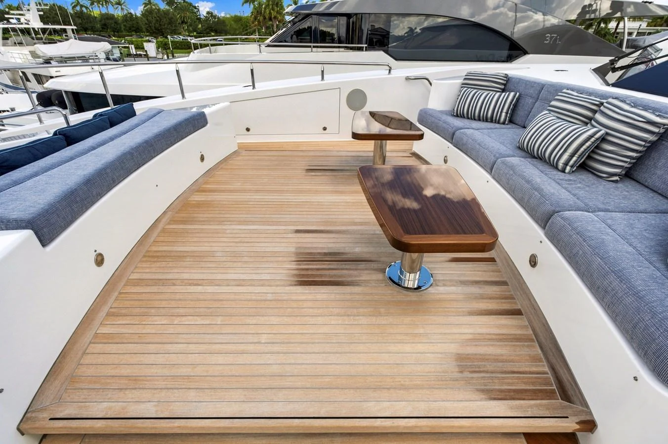 The aft deck features comfortable seating with stylish cushions and sleek wooden tables, perfect for outdoor relaxation. aboard SEAS THE DAY Yacht for Sale