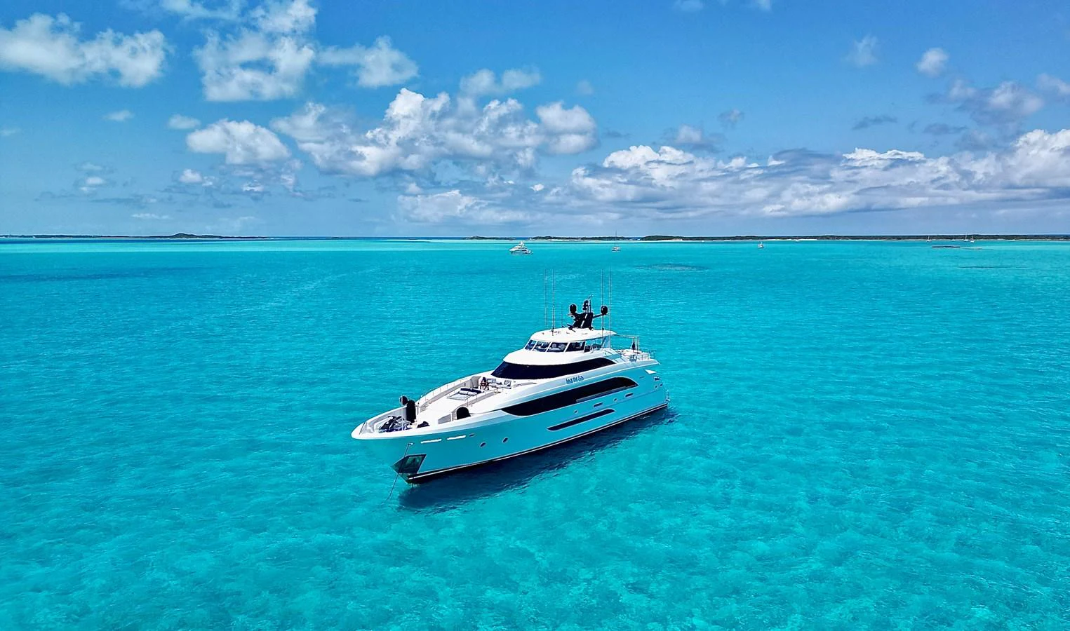 A luxurious yacht cruises through crystal-clear turquoise waters under a bright blue sky. aboard SEAS THE DAY Yacht for Sale