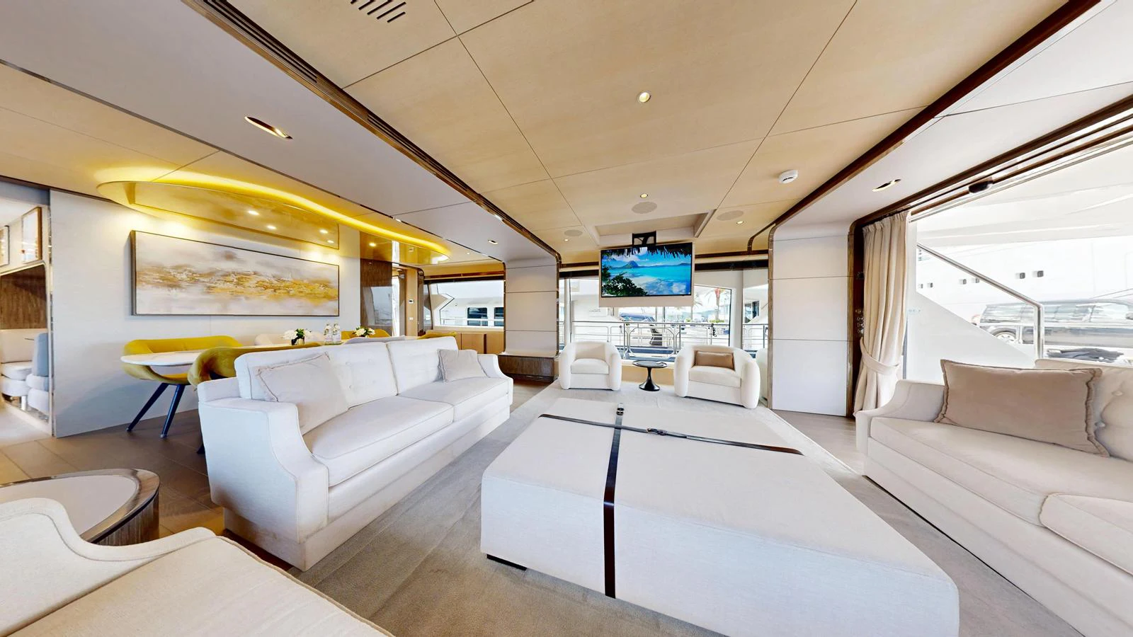 The spacious salon features elegant seating, a large ottoman, and a flat-screen TV, creating a luxurious and comfortable environment. aboard 98.92' AZIMUT GRANDE Yacht for Sale