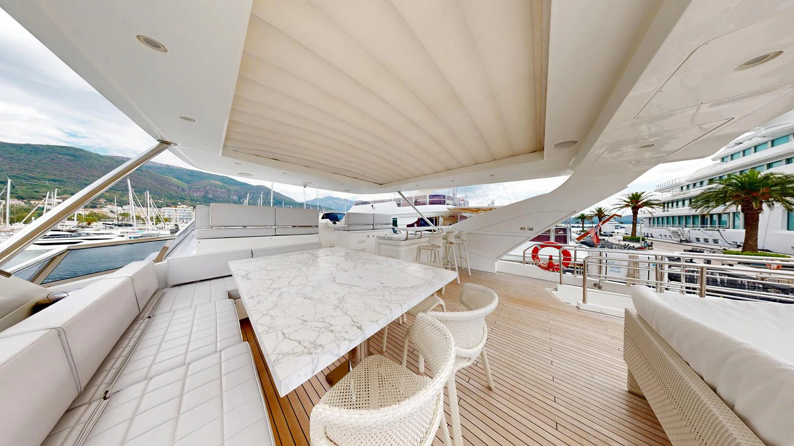The aft deck features a spacious seating area with a large marble table, perfect for alfresco dining and relaxation. aboard 98.92' AZIMUT GRANDE Yacht for Sale