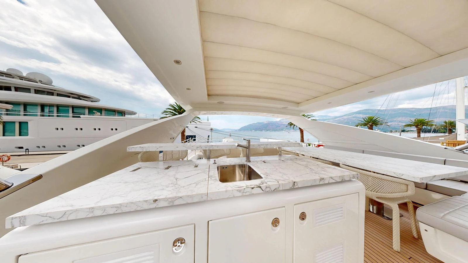 The flybridge features a sleek marble countertop with a built-in sink, offering a luxurious outdoor kitchen space. aboard 98.92' AZIMUT GRANDE Yacht for Sale