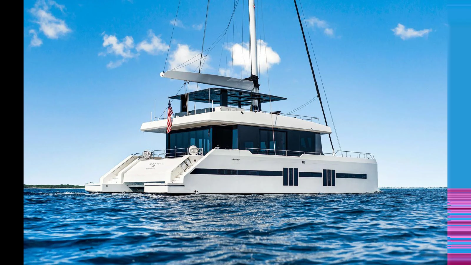 A sleek and modern catamaran yacht glides gracefully on calm waters under a clear blue sky. aboard MIDORI Yacht for Sale
