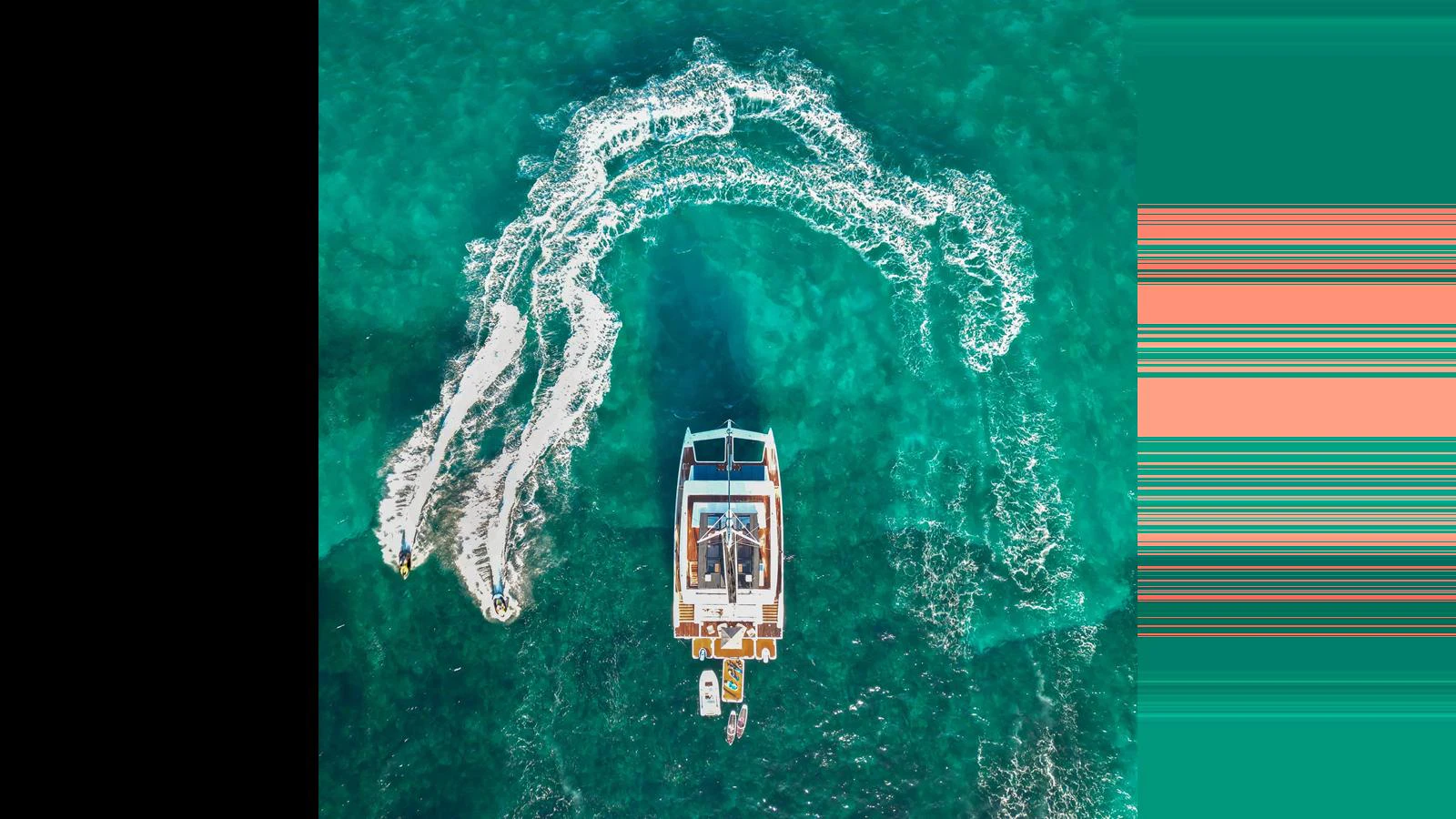 An aerial view of a yacht cruising through clear turquoise waters, leaving a trail of white wake behind. aboard MIDORI Yacht for Sale