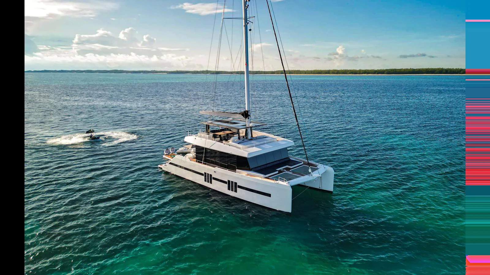 A sleek catamaran yacht glides gracefully on calm, turquoise waters under a clear sky. aboard MIDORI Yacht for Sale