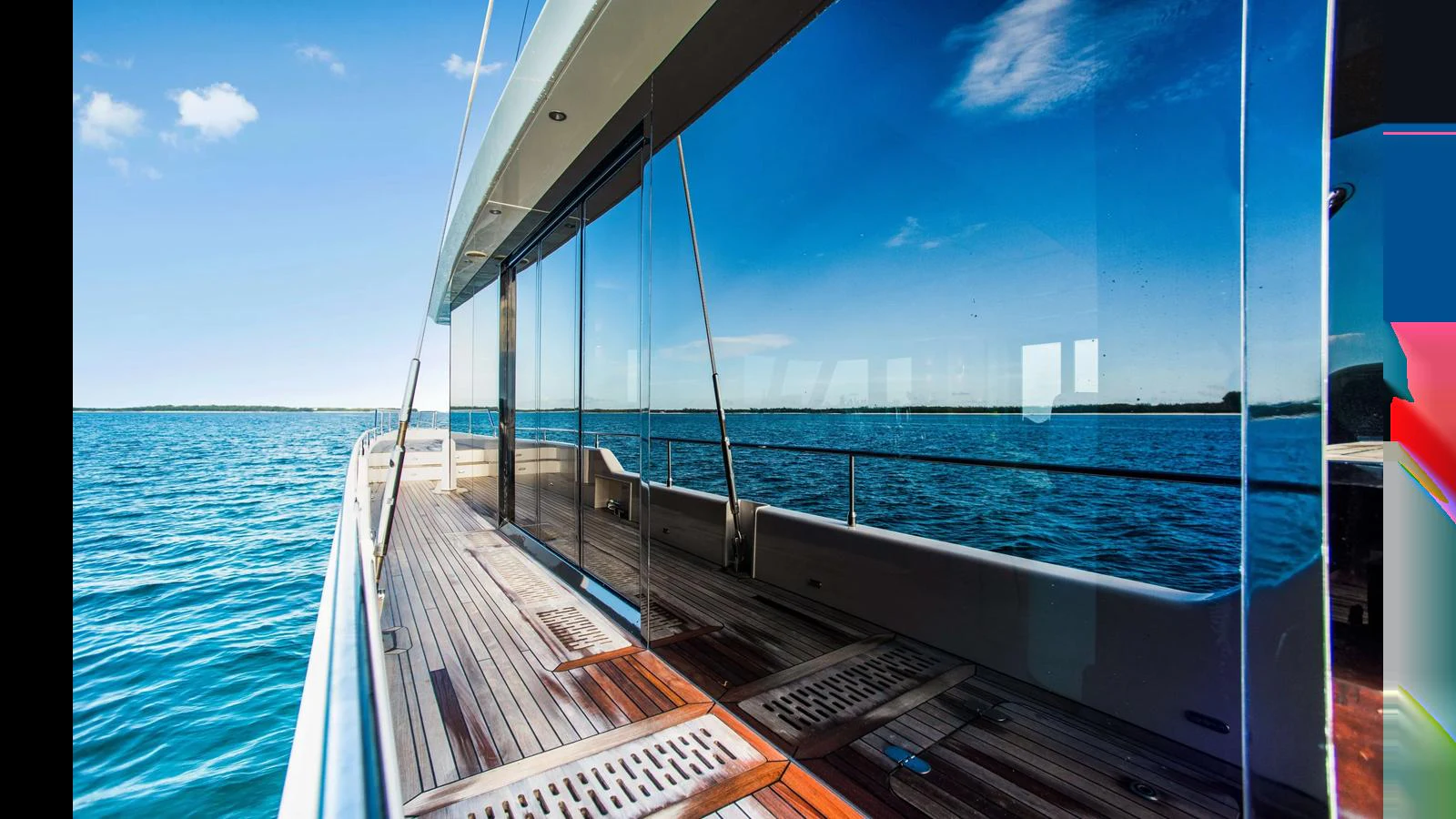 The yacht's side deck features sleek lines and expansive glass windows, offering stunning views of the surrounding waters. aboard MIDORI Yacht for Sale