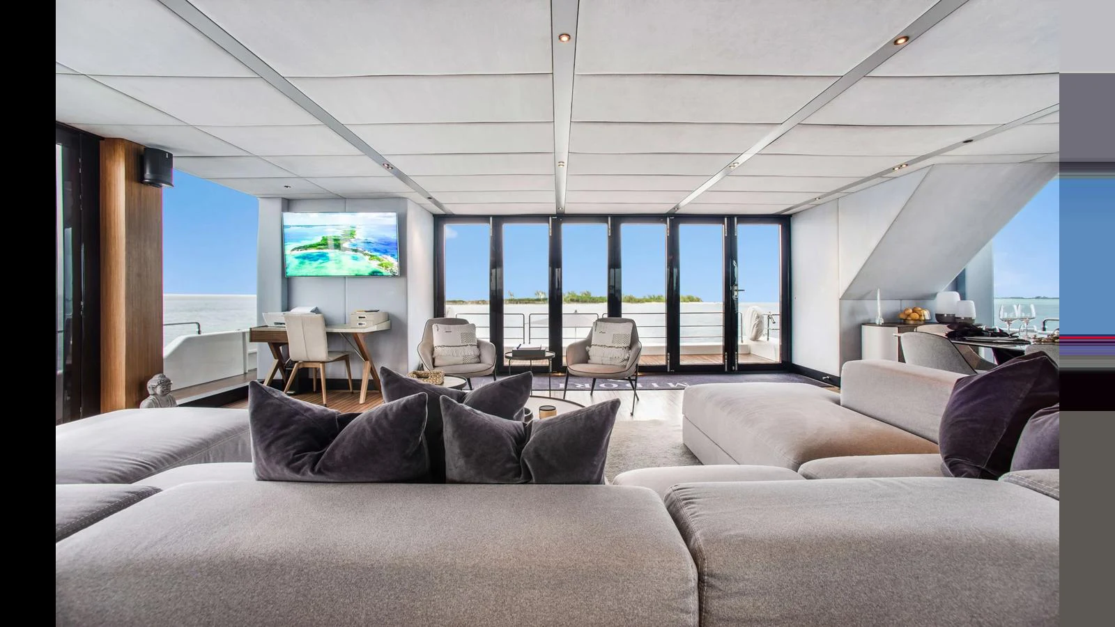 The salon features plush seating, a large TV, and expansive windows offering stunning views. aboard MIDORI Yacht for Sale
