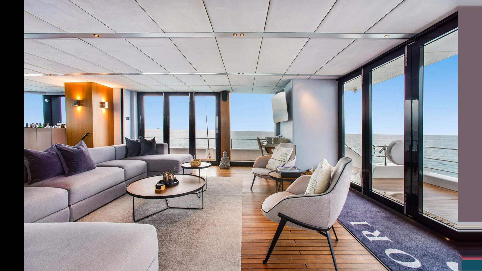 The salon features modern furnishings with ample seating and large windows offering stunning ocean views. aboard MIDORI Yacht for Sale