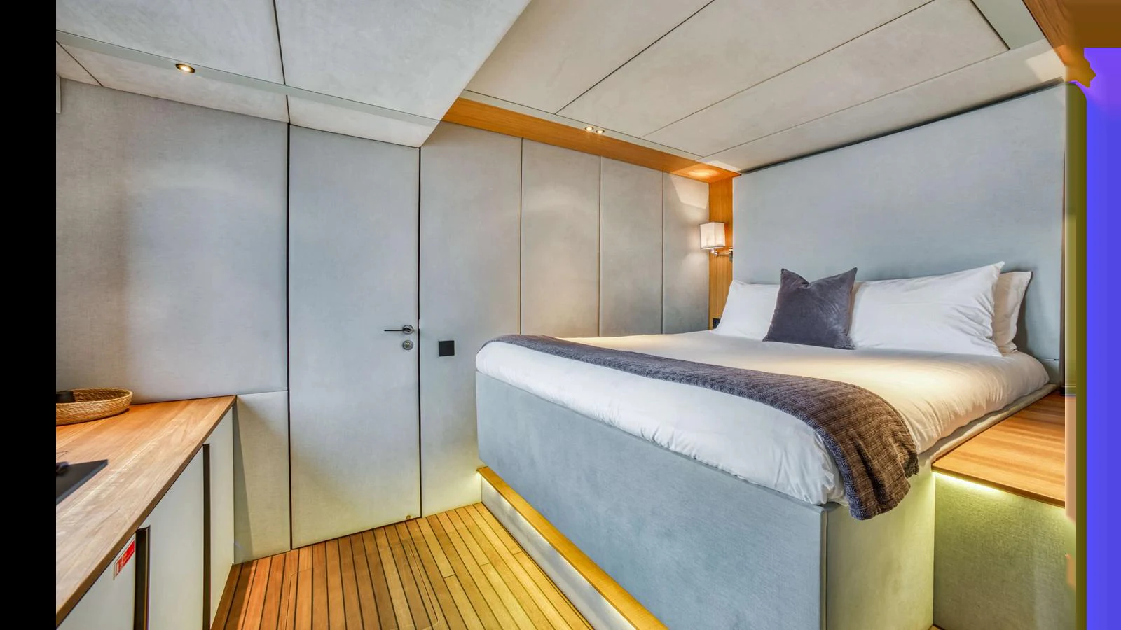The stateroom features a luxurious bed with modern lighting and elegant wood flooring. aboard MIDORI Yacht for Sale