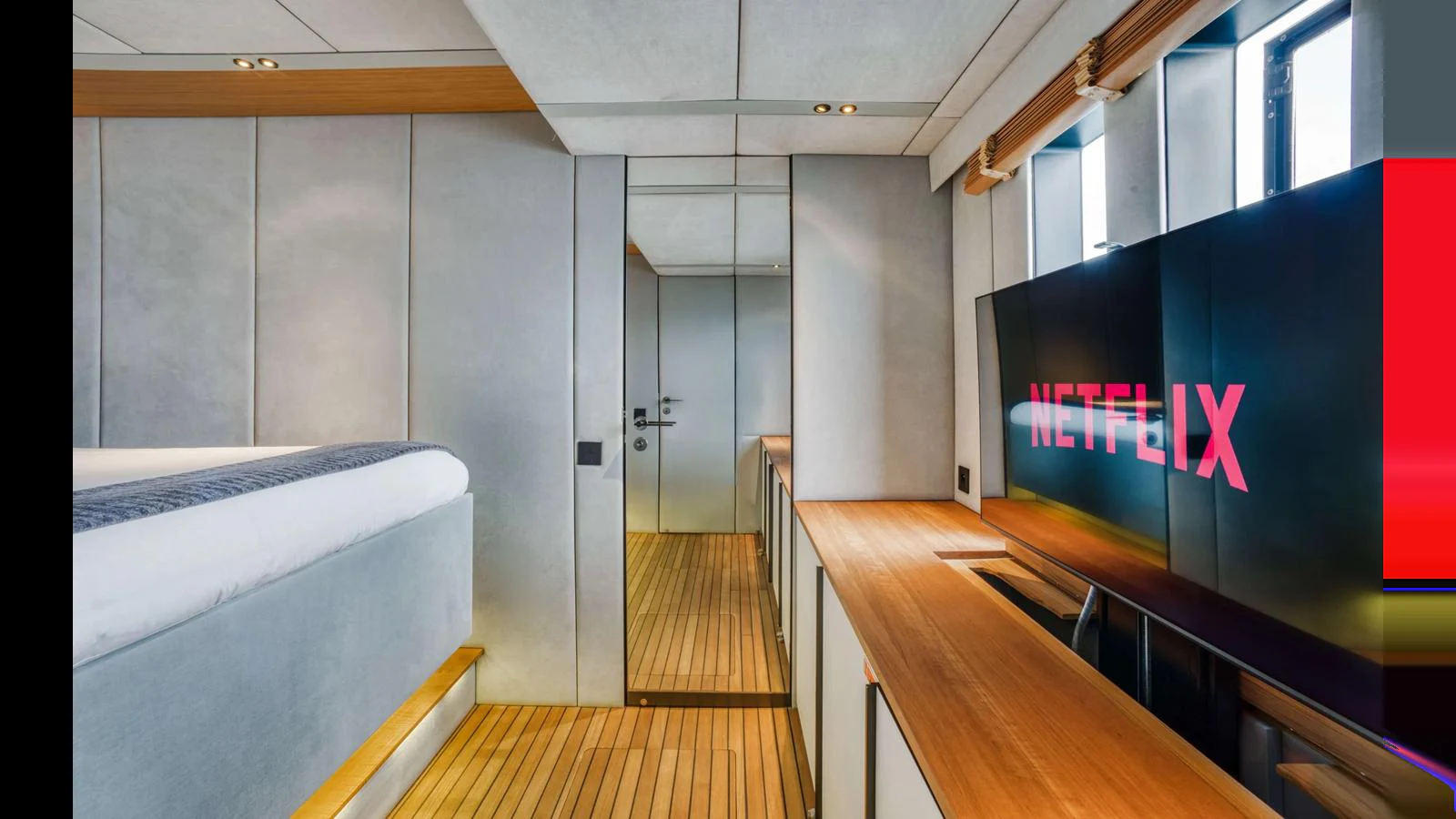 The yacht's interior features a modern entertainment area with a large screen and sleek wooden accents. aboard MIDORI Yacht for Sale